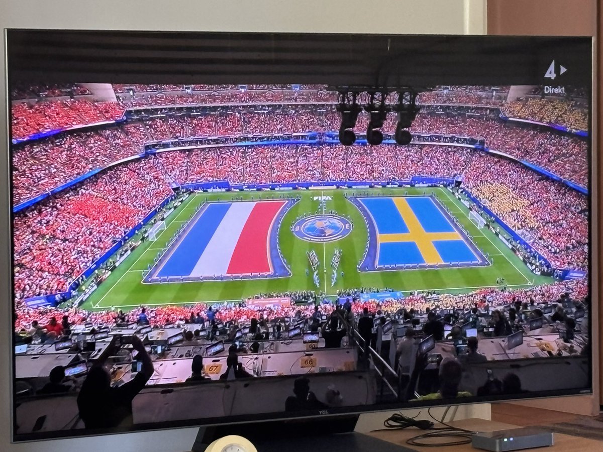Tv-bild från fotbollsarena med två enorma flaggor: Nederländerna och Sverige